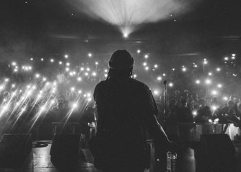 Arkası dönüp rap'ci sahnede şarkı söylüyor.